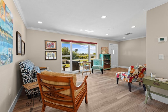 sitting room featuring crown molding and light hardwood / wood-style flooring