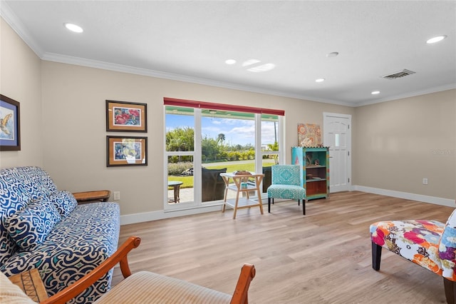 sitting room featuring crown molding and light hardwood / wood-style flooring