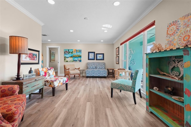 sitting room with light wood-type flooring and ornamental molding