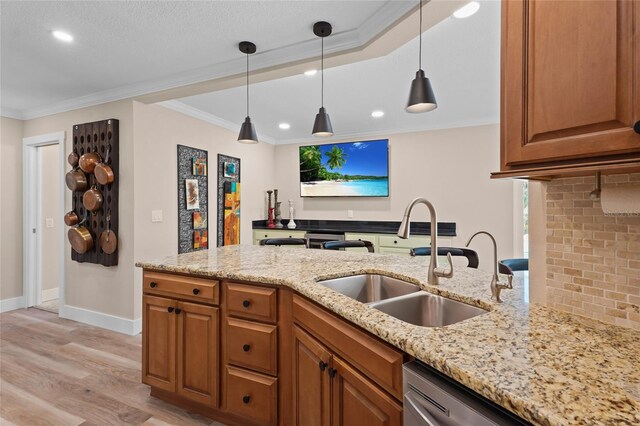 kitchen with light stone countertops, sink, light hardwood / wood-style floors, and ornamental molding