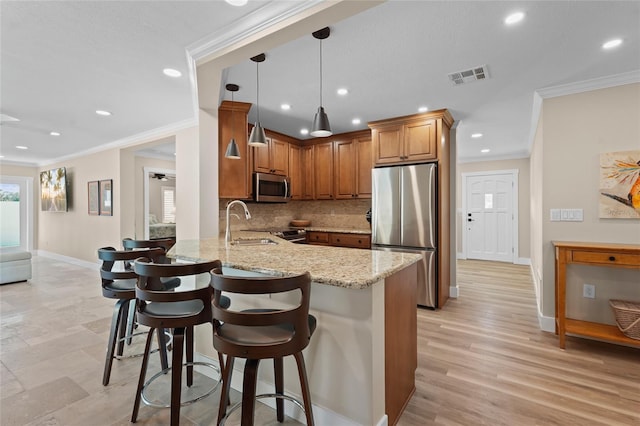 kitchen with kitchen peninsula, backsplash, light stone counters, stainless steel appliances, and sink