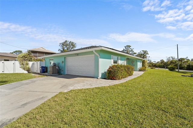 view of front of home with central AC unit, a front yard, and a garage