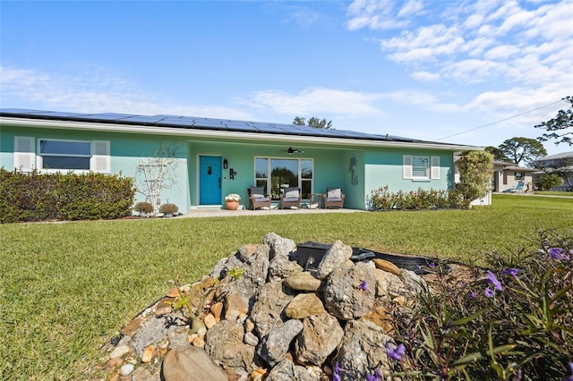 ranch-style house featuring ceiling fan, a front lawn, and solar panels