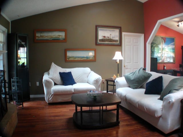 living room featuring lofted ceiling and dark wood-type flooring