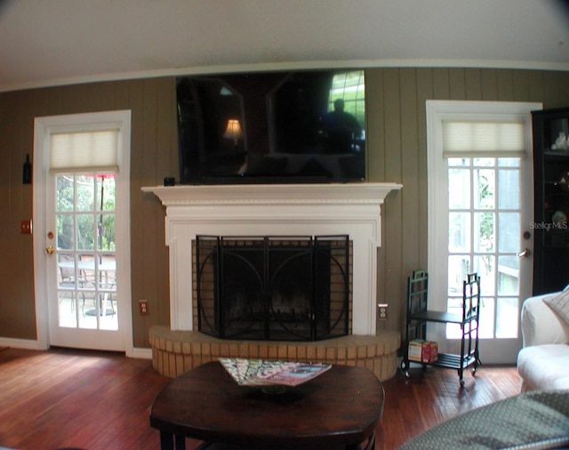 living room with ornamental molding, a fireplace, and hardwood / wood-style flooring