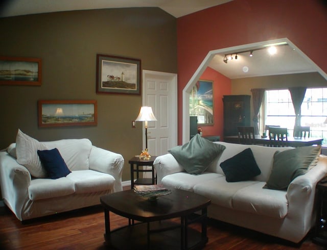 living room with dark hardwood / wood-style flooring and vaulted ceiling