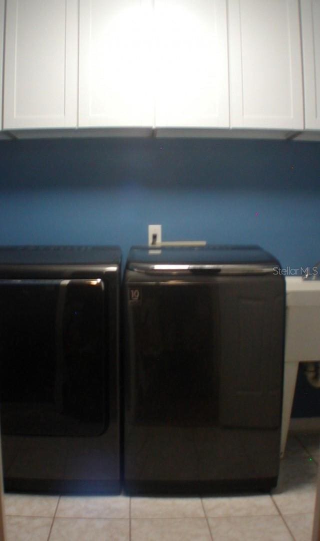 laundry room with cabinets and light tile patterned floors