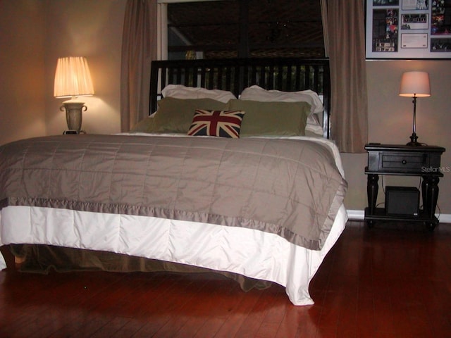 bedroom with dark wood-type flooring