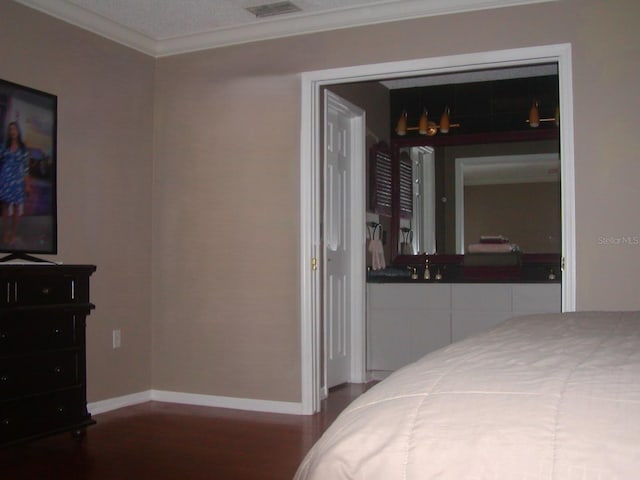 bedroom featuring hardwood / wood-style floors, a textured ceiling, a closet, and crown molding