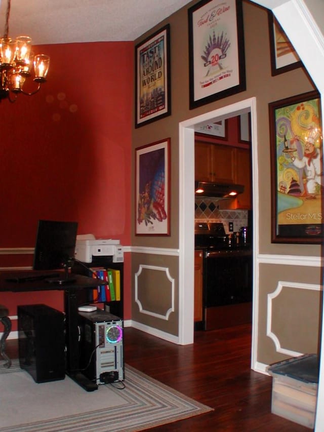 office space with an inviting chandelier and dark hardwood / wood-style floors