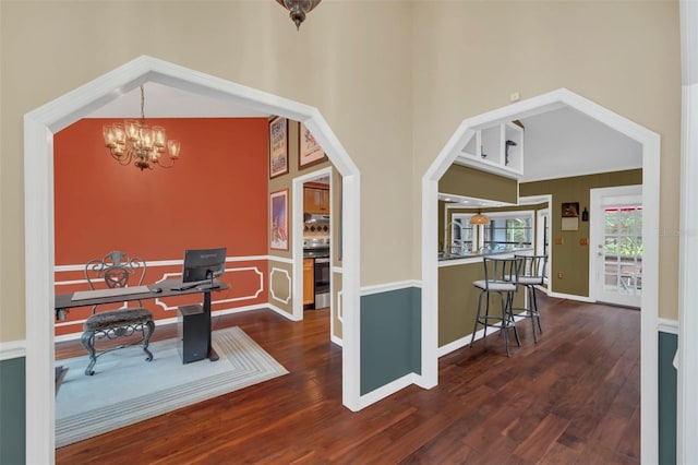 interior space with a notable chandelier, dark wood-type flooring, and a high ceiling