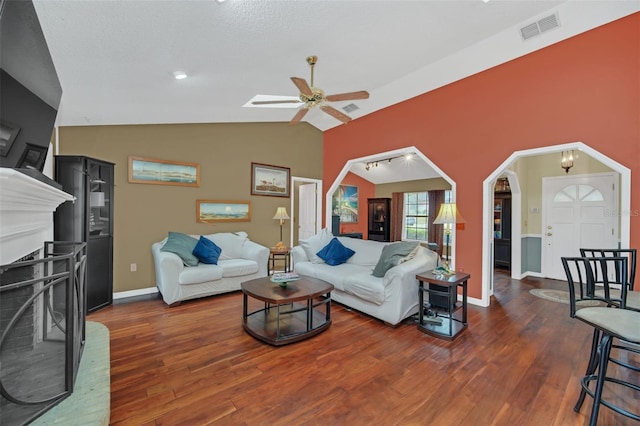 living room with vaulted ceiling, dark hardwood / wood-style floors, and ceiling fan