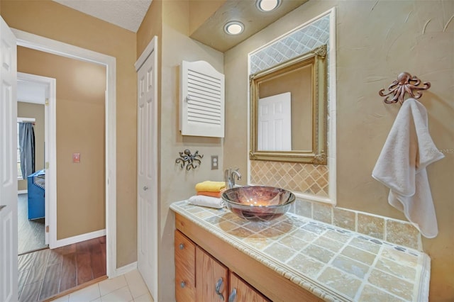 bathroom featuring tasteful backsplash, vanity, and tile patterned flooring