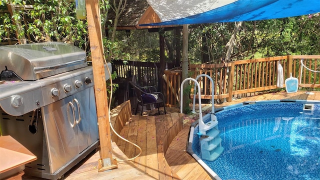 view of swimming pool featuring area for grilling and a deck