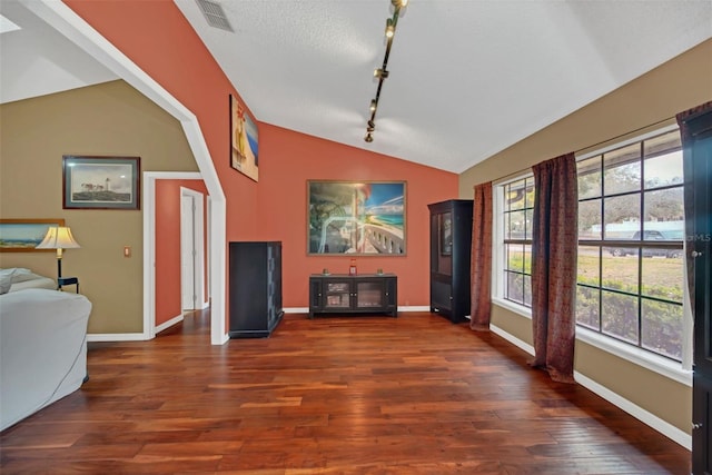 living room with rail lighting, lofted ceiling, dark hardwood / wood-style floors, and a textured ceiling