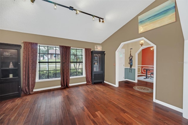 entrance foyer with lofted ceiling, a textured ceiling, and dark hardwood / wood-style flooring