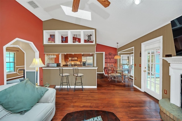 living room featuring vaulted ceiling, dark wood-type flooring, and ceiling fan