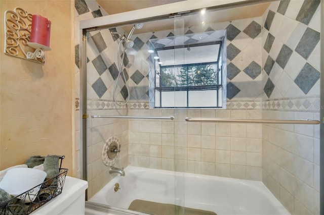 bathroom with shower / bath combination with glass door and toilet