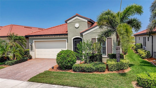 mediterranean / spanish house featuring a front yard and a garage