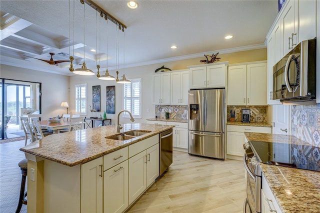 kitchen with plenty of natural light, appliances with stainless steel finishes, sink, and a kitchen island with sink