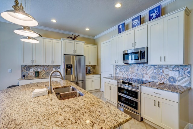 kitchen with stainless steel appliances, white cabinets, sink, ornamental molding, and decorative light fixtures