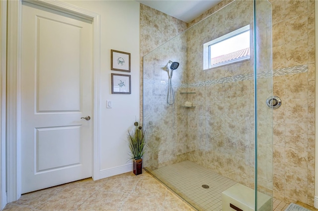 bathroom with a tile shower and tile patterned floors