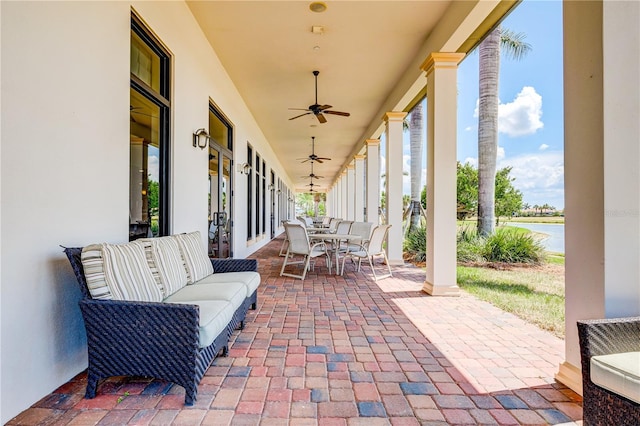 view of patio / terrace with an outdoor living space, a water view, and ceiling fan