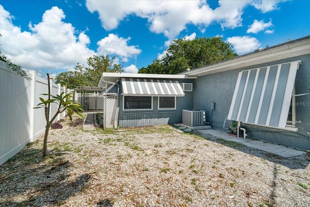 rear view of house featuring central air condition unit