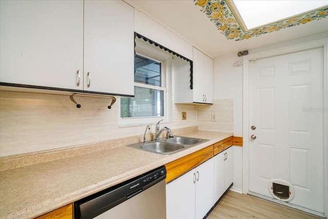 kitchen with white cabinetry, light hardwood / wood-style floors, sink, and stainless steel dishwasher