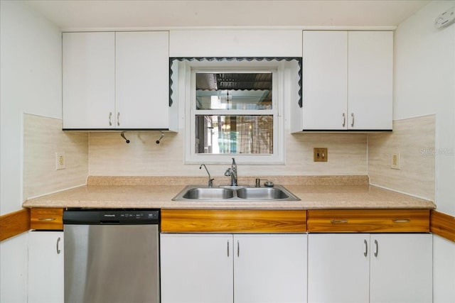 kitchen featuring backsplash, white cabinetry, sink, and stainless steel dishwasher