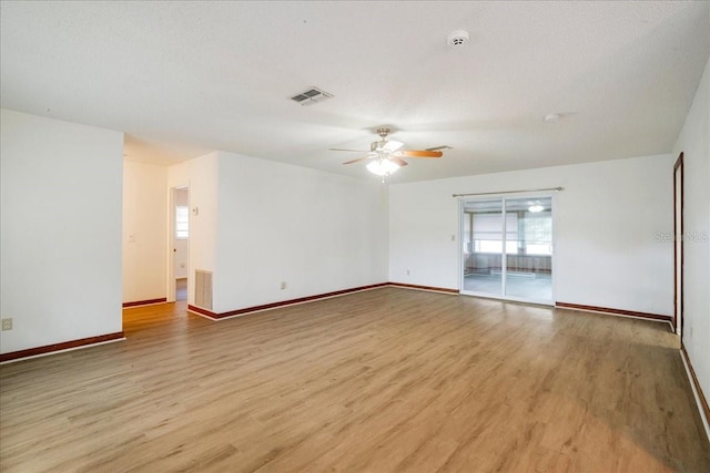 empty room featuring light hardwood / wood-style flooring, ceiling fan, and a textured ceiling