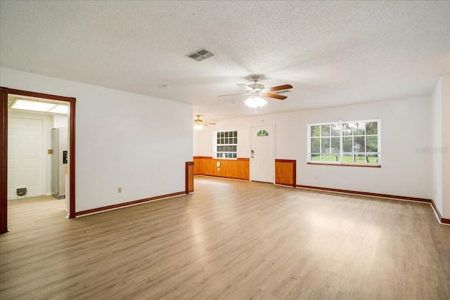 empty room with a textured ceiling, hardwood / wood-style floors, and ceiling fan