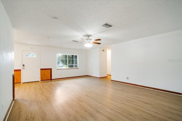 spare room featuring ceiling fan, a textured ceiling, and light hardwood / wood-style flooring