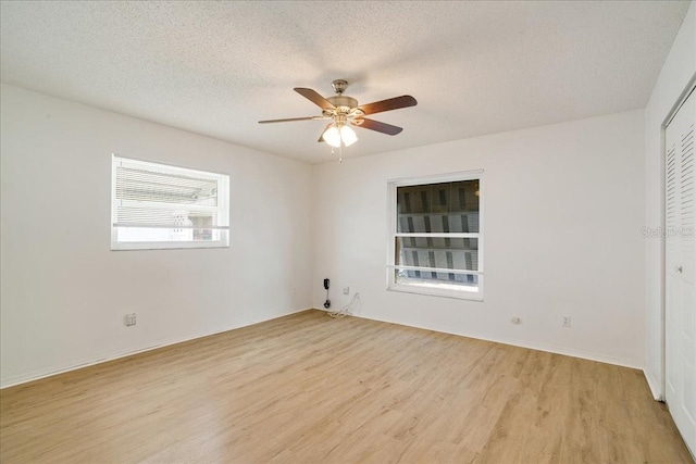 empty room featuring ceiling fan, a textured ceiling, and light hardwood / wood-style flooring