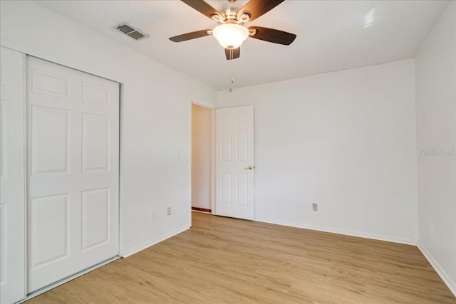 unfurnished bedroom featuring ceiling fan, a closet, and light hardwood / wood-style floors