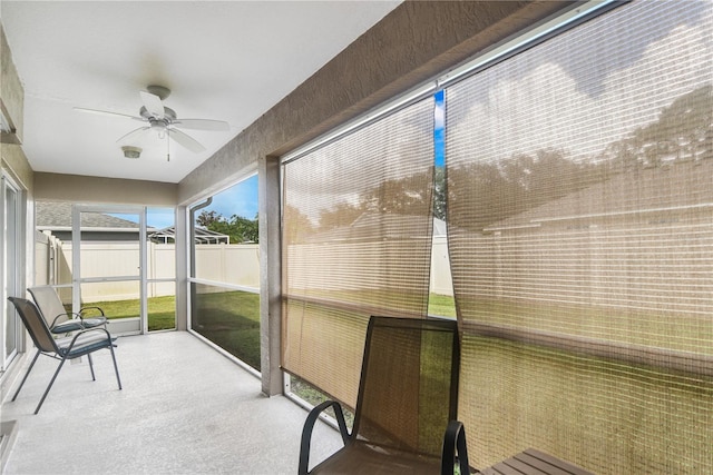 unfurnished sunroom with ceiling fan