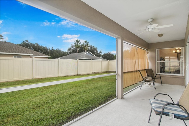 unfurnished sunroom featuring ceiling fan