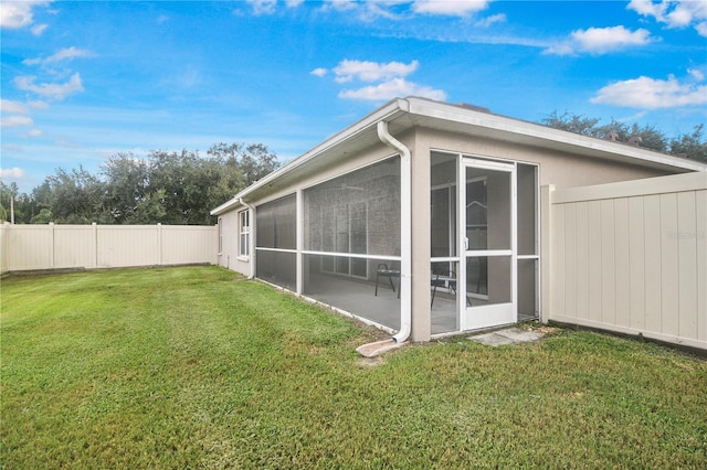 exterior space with a yard and a sunroom