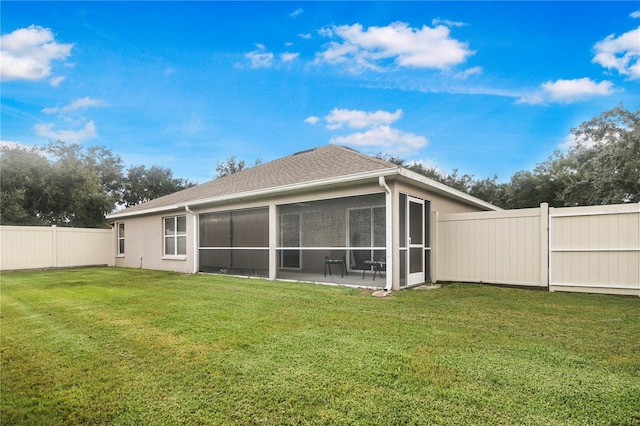 back of house with a yard and a sunroom