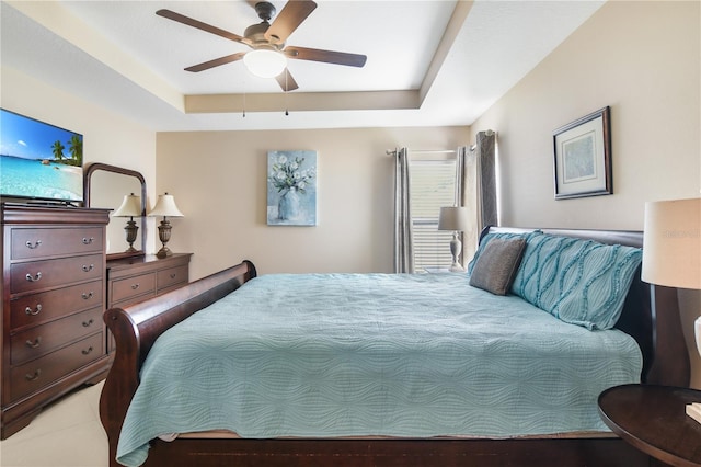 bedroom with ceiling fan and a raised ceiling