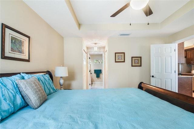 bedroom with ceiling fan and a tray ceiling