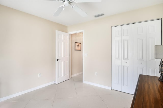 unfurnished bedroom with a closet, ceiling fan, and light tile patterned flooring