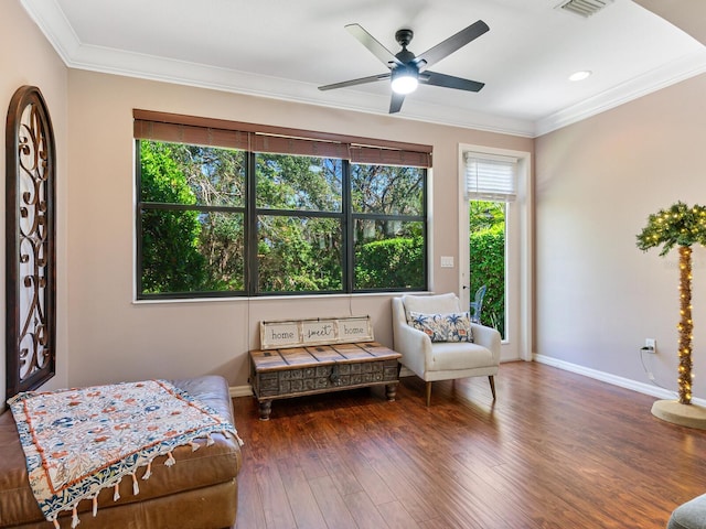 sitting room featuring dark wood-type flooring, ceiling fan, and ornamental molding