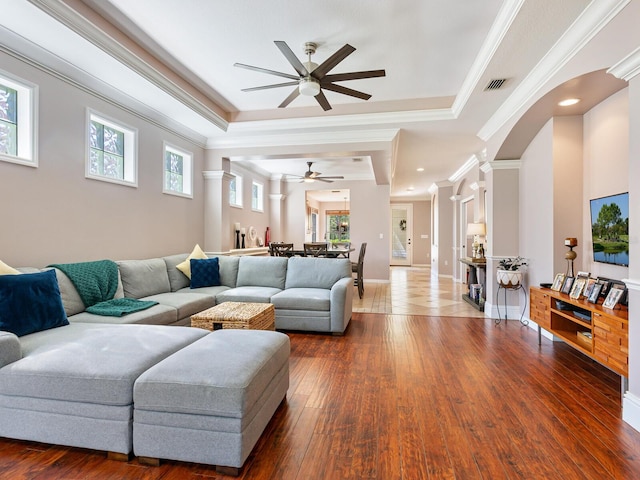 living room with crown molding, dark wood-type flooring, and ornate columns