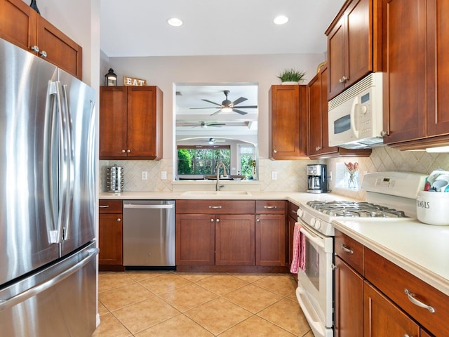 kitchen featuring stainless steel appliances, sink, ceiling fan, light tile patterned floors, and tasteful backsplash