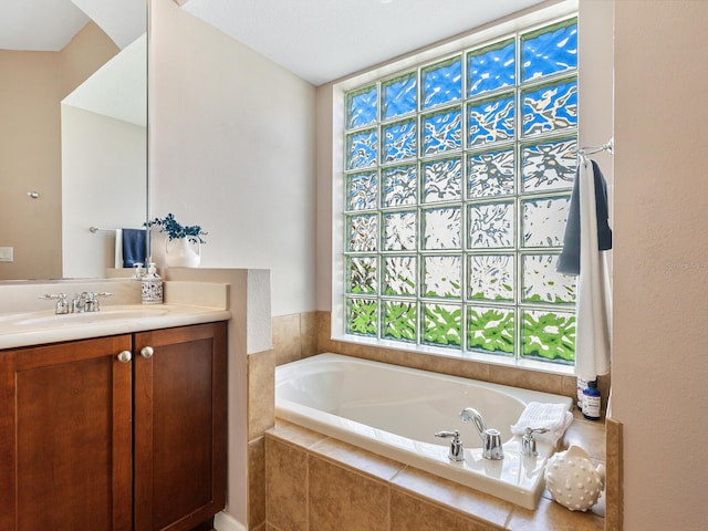 bathroom with vanity and tiled tub