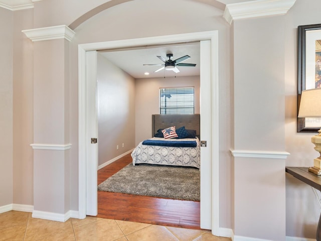 bedroom with crown molding, light wood-type flooring, and ceiling fan