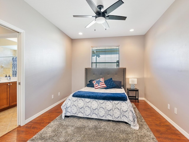 bedroom featuring hardwood / wood-style floors, ensuite bathroom, and ceiling fan