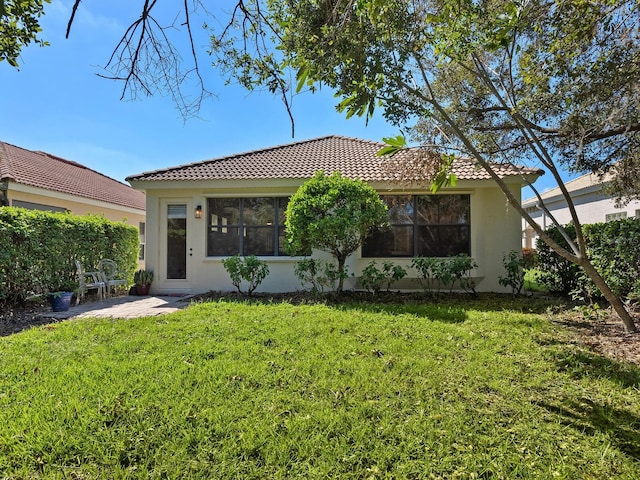 rear view of house featuring a patio area and a lawn