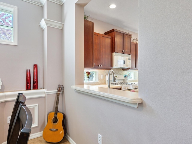 kitchen featuring white appliances, backsplash, sink, and plenty of natural light